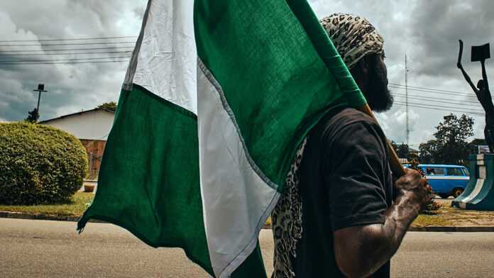 Un homme tenant le drapeau du Nigeria